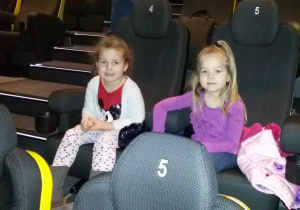 Widok na dwie dziewczynki siedzące na widowni kinowej.
